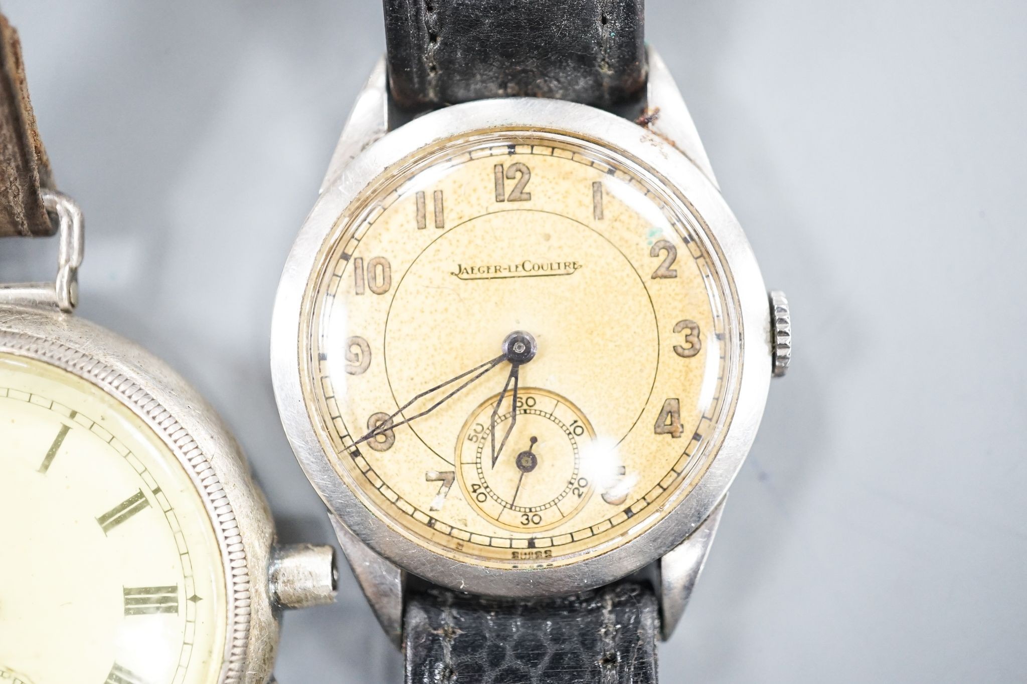 A gentleman's stainless steel Jaeger LeCoultre manual wind wrist watch, case back numbered 64765, on associated strap and a white metal fob watch, now mounted as a wrist watch(a.f.).